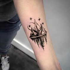 a person with a tattoo on their arm that has mountains and stars in the sky