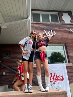 two young women standing on steps in front of a building holding up the letters ad