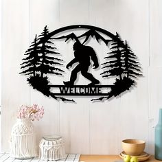 a metal wall hanging with a bigfoot and the words welcome in front of it