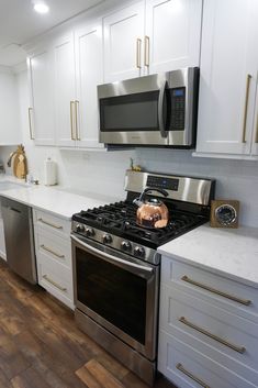 a kitchen with white cabinets and stainless steel appliances