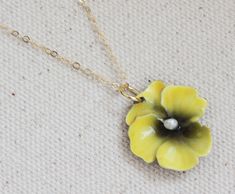 "From my vintage botanical collection This adorable pansy pin gone pendant, necklace features a rare vintage yellow enamel pansy flower center stage is a fresh water pearl. Great gift for the flower lover in your life Hangs from a fine 14 karat gold filled chain. The Pansy is 1 \" wide, vintage elements are in excellent condition. ** The last photo show's a different pansy same size with a bird charm , the bird charm is also offered on this listing Spring closure clasp Photoed with a 16\" chain Yellow Flower Shaped Necklace Gift, Handmade Yellow Gold Flower-shaped Necklace, Delicate Yellow Flower Necklace, Pansy Jewelry, Yellow Enamel Flower Shaped Jewelry, Pansy Necklace, Yellow Pansy, Yellow Flower Necklace, Vintage Yellow Enamel Jewelry