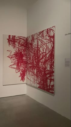 an abstract painting on display in a museum with white walls and red artwork hanging from the wall