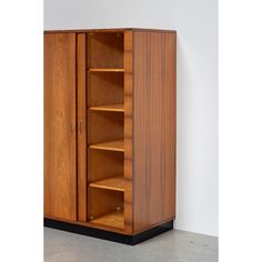 a tall wooden cabinet with shelves in it