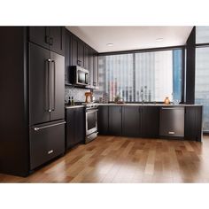 an empty kitchen with black cabinets and stainless steel appliances in front of a large window