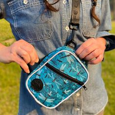 Dragonflies zip and dart in a dizzying dance to catch Mayfly snacks against an aqua blue river scene. This pattern is inspired by the Cahaba River in Alabama. People familiar with the majestic Cahaba Lily might recognize them silhouetted in the background. Our Snapshot Bag is the perfect little crossbody! You can also attach one end of your strap to the alternate d-ring on the bottom to convert to a chest bag. The Snapshot is compact and lightweight, but with plenty of room for your phone, cards Blue Bags With Ykk Zipper For Outdoor Activities, Outdoor Blue Bag With Zipper Pouch, Blue Outdoor Bags With Ykk Zipper, Blue Outdoor Bag With Zipper Pouch, Blue Zipper Pouch Bag For Outdoor, Mayfly, Blue River, Chest Bag, Front Zipper