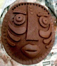 a face made out of chocolate sitting on top of a piece of paper