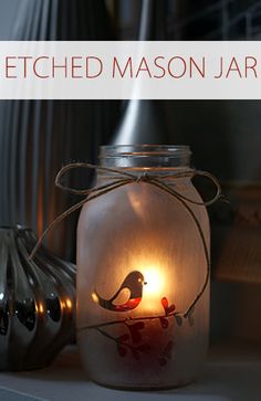 a mason jar with a lit candle in it sitting on a shelf next to other items