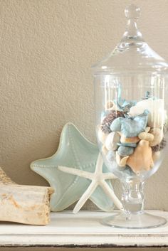 a glass jar filled with sea shells and starfish