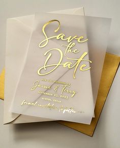 a white and gold save the date card on top of two yellow envelopes,