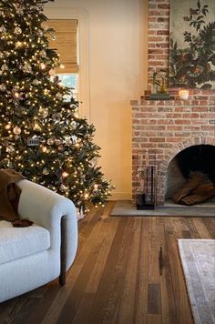 a living room with a christmas tree in the corner and a couch next to it