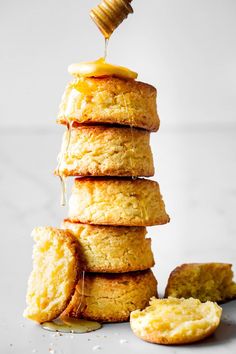 a stack of biscuits with honey being drizzled over them and stacked on top of each other