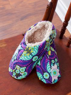 a pair of slippers sitting on top of a wooden chair