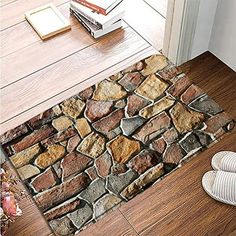 a pair of shoes sitting on the floor next to a door mat that has rocks in it