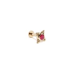 a gold cufflink with a red stone in the center