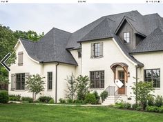 a large white house with black roof and windows