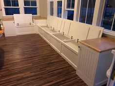 an empty kitchen with white cabinets and wooden flooring is pictured in this image from the front