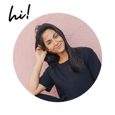 a woman with long black hair is smiling at the camera and has her hand on her head