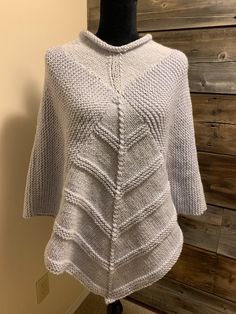 This lovely lady's poncho is fashionably light weight. It is perfect for work or a night out, cool spring days and summer nights around the campfire. A beautiful light gray make it the perfect find.  It is made with a blended yarn and can be washed in cold water (lay flat to dry).  It measures 26 inches from neck to wrist. Knitted Shawl Poncho For Fall, One Size Knitted Poncho, One Size Knit Poncho, Hand Knitted One Size Poncho, Knit Fabrication One Size Shawl Poncho, Oversized Knit Shawl Poncho, One Size Knit Poncho Shawl, Oversized Knitted Shawl Poncho, Knitted One Size Poncho With Batwing Sleeves