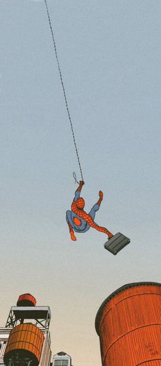 a spider man is being pulled by a rope from the top of a large building