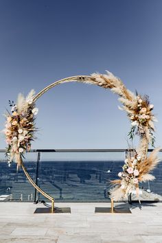 a wedding arch decorated with flowers and feathers