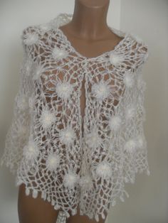 a white crocheted top on a mannequin's torso with flowers