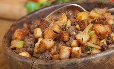 a wooden bowl filled with food on top of a table