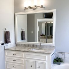 a bathroom with a sink, mirror and bathtub in it's center area