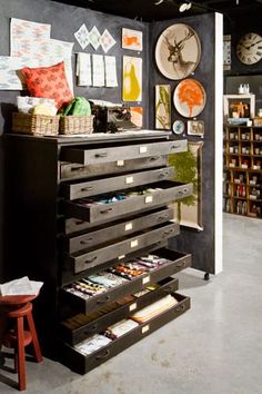 a room filled with lots of drawers and pictures on the wall next to bookshelves