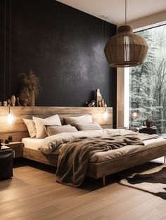 a bedroom with black walls and wooden floors has a large bed in the center, along with two lamps hanging from the ceiling