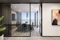 an office with large glass doors leading to a meeting room and conference table in the center