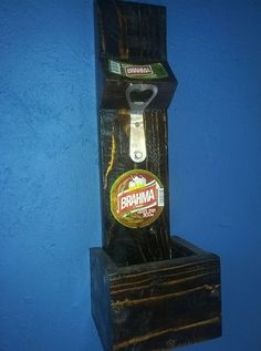 a bottle opener hanging from the side of a blue wall next to a wooden box