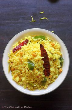 a white bowl filled with yellow rice and vegetables