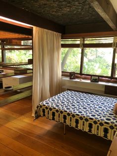 a bed sitting under a window next to a wooden floor