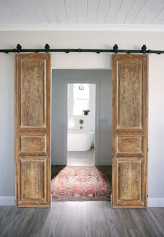 an open door leading to a bathroom with a rug on the floor in front of it