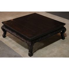 a wooden coffee table sitting on top of a rug