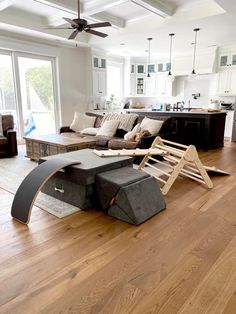 a living room filled with furniture next to a kitchen and an open floor plan area