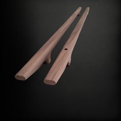 two pieces of wood sitting next to each other on a black surface with one piece missing