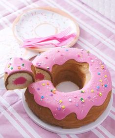 a donut with pink frosting and sprinkles is on a plate