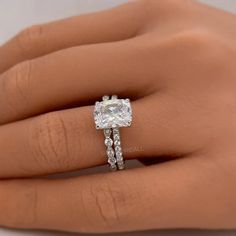 a woman's hand with a diamond ring on her finger and an engagement band