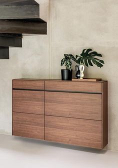 a wooden cabinet with two plants on top