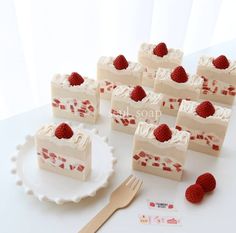 several pieces of cake with raspberries on them and a fork next to it