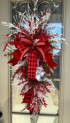 a red and white christmas wreath on the front door