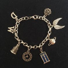 a charm bracelet with charms on it sitting on a table next to a black surface