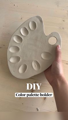 a hand holding a white tray with holes in it and the words diy color palette holder