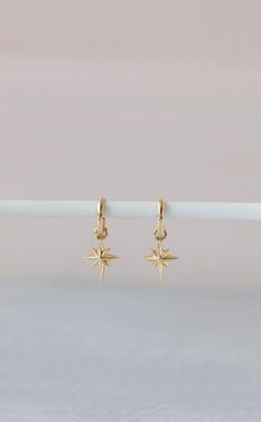 Indulge in the celestial elegance of our Northstar Earrings. Crafted from luxurious 14K gold, these earrings feature a delicate northstar charm that adds a touch of sophistication to any outfit. Elevate your style and shine like a star with these exquisite earrings. Elegant Dangle Hoop Earrings With Star Charm, Elegant Gold Hoop Earrings With Star Charm, North Star Earrings, Dainty Gold-plated Earrings With Star Charm, Dainty Yellow Gold Star Charm Earrings, Dainty 14k Gold Star Charm Earrings, Dainty Gold Plated Earrings With Star Charm, Dainty Yellow Gold Earrings With Star Charm, Dainty 14k Gold Earrings With Star Charm