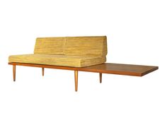 a couch that is sitting on top of a wooden table with a shelf underneath it