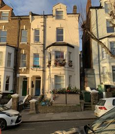 a row of houses with cars parked on the street