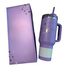 a purple travel mug with stars on it next to a cardboard box