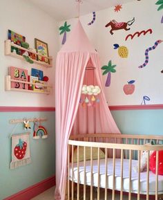 a child's bedroom with a pink canopy bed and colorful wall decals on the walls