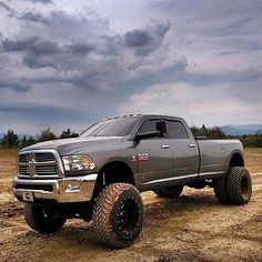 a large gray truck parked on top of a dirt field